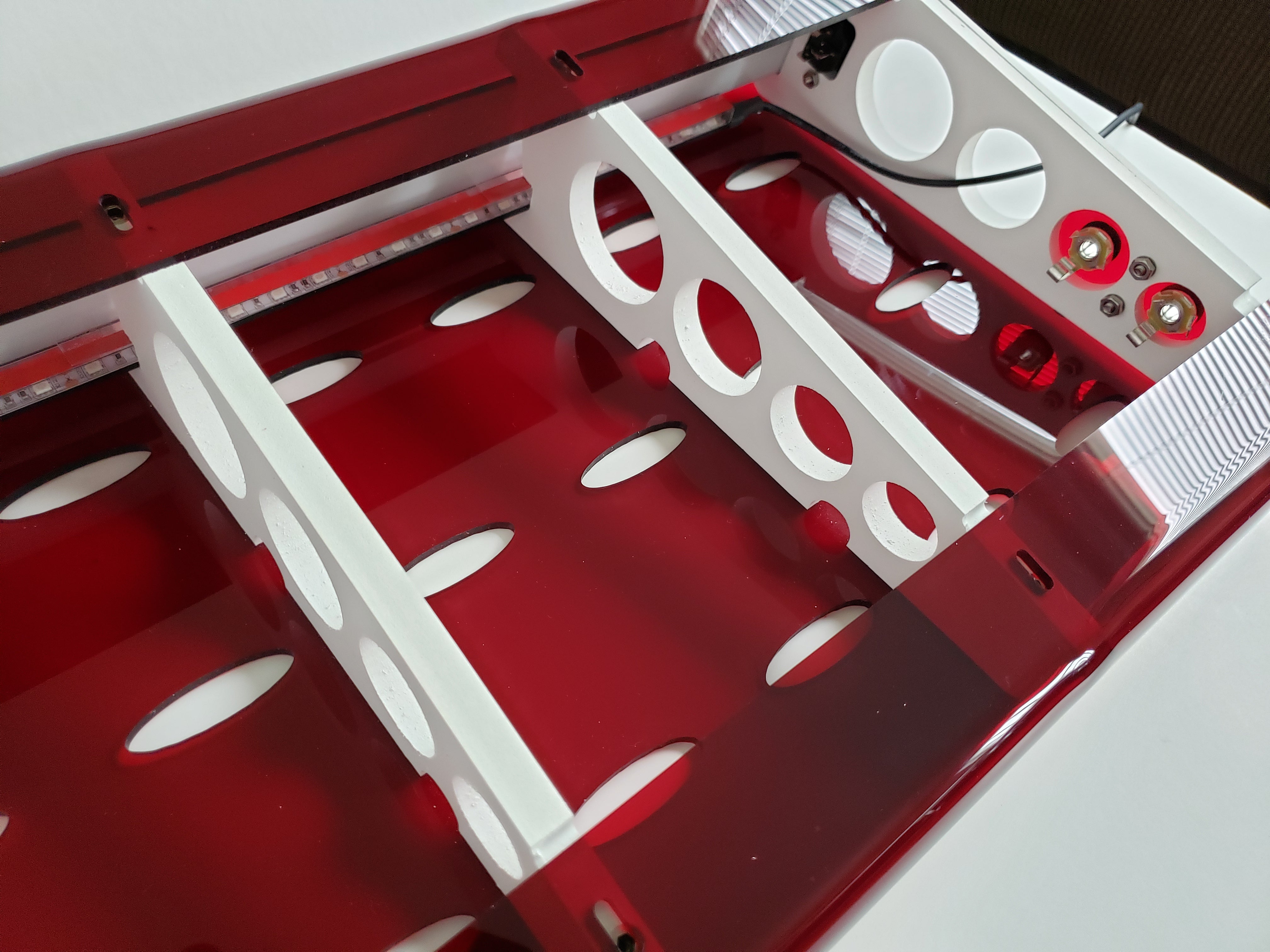 Inside view of Bratco BoxWing illuminated pedalboard, ruby red with white trusses